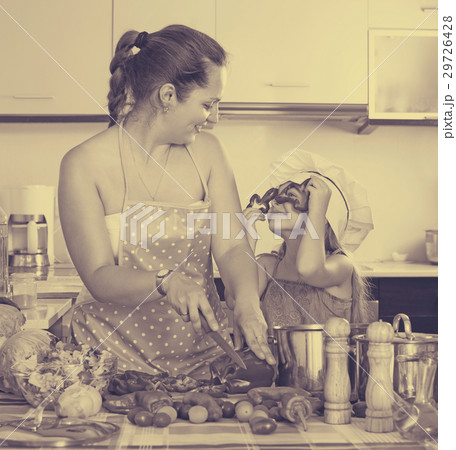 Little girl with mom at kitchen. 29726428