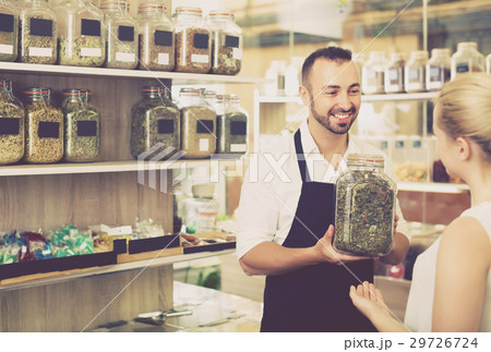 Man holding glass can with dried herbs Man holding glass can with dried herbs 29726724