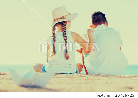 boy and girl sitting beach 29726725