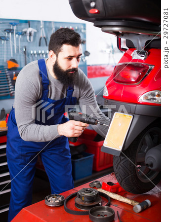 Worker repairing in motorcycle workshop Worker repairing in motorcycle workshop 29727081