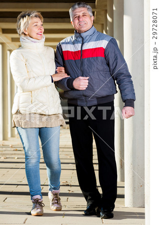 Married couple goes for walk between concrete pillars 29728071