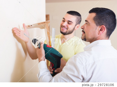 Son and father drilling wall 29728106