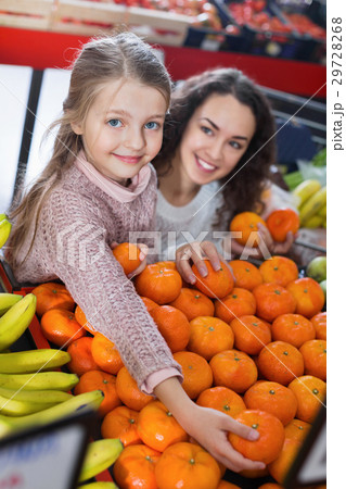 Mother and small daughter buying citrus fruits 29728268