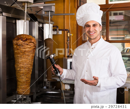 Young male chef with meat on grill Young male chef with meat on grill 29728431