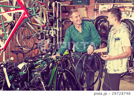 Man and teenage boy choosing new wheel 29728746