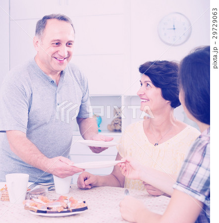 senior man serving family lunch at home . 29729063