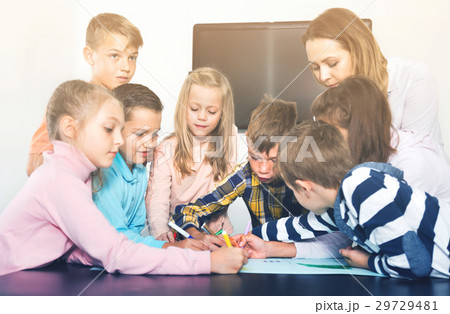 Children with teacher drawing together in classroom 29729481