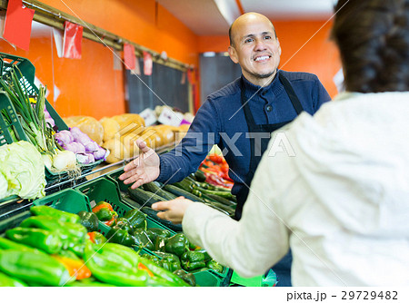 Salesman serving buyer purchasing veggies 29729482