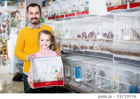 Father and daughter enjoying their purchase of canary bird in pet shop 29729556