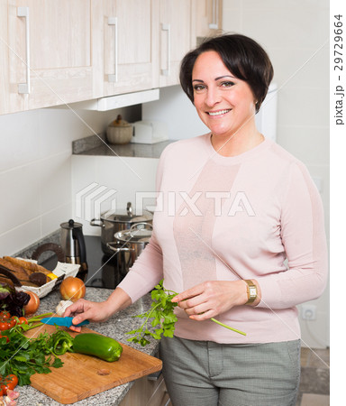 Positive housewife cooking veggies at home 29729664