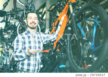 Man in sports workshop mounts bike using special tools 29730037