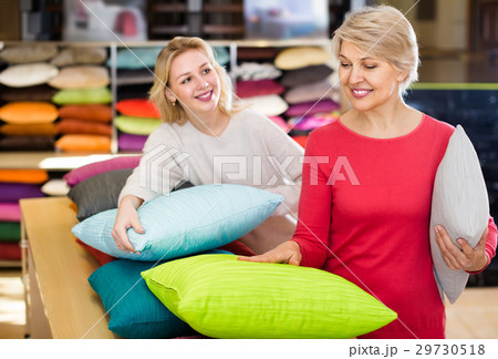 attentive young and senior female customers looking through pillows in textile shop attentive young and senior female customers looking through pillows in textile shop 29730518