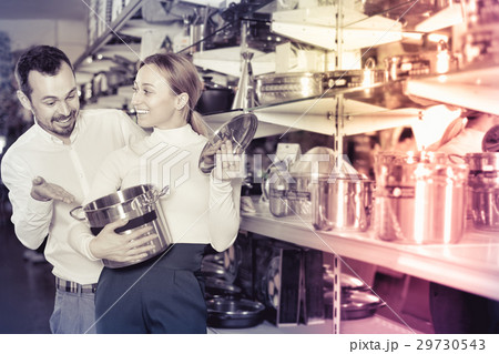 Young couple choosing new saucepan in dinnerware store 29730543