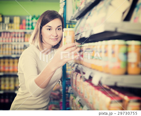 Cheerful female shopper searching for baby food 29730755