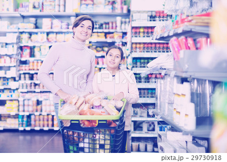 Woman with girl looking for food in supermarket 29730918