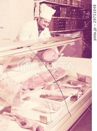 Man seller at the counter with meat . 29731048