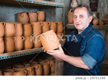 Elderly potter at ceramic workshop. Elderly potter at ceramic workshop. 29731166