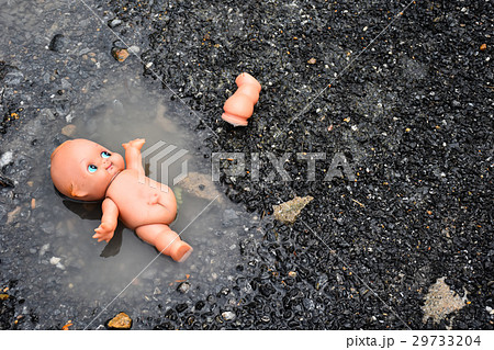 abandoned baby doll in the water on the road 29733204