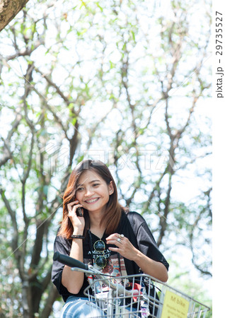 woman on a bicycle talking on the mobile phone woman on a bicycle talking on the mobile phone 29735527