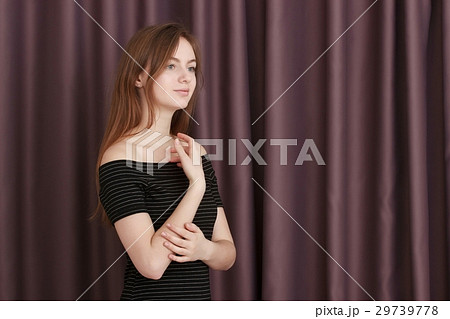 Young girl with black dress against curtains 29739778
