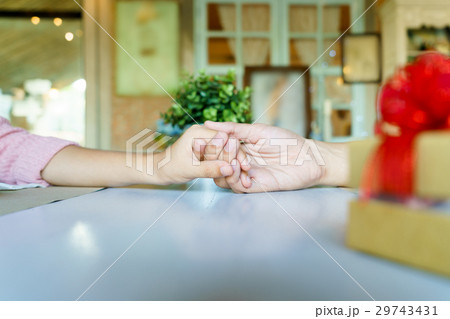 A couple holding hands each other with a gift A couple holding hands each other with a gift 29743431