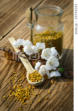 Grains of bee pollen in jar and wooden spoon on 29744283