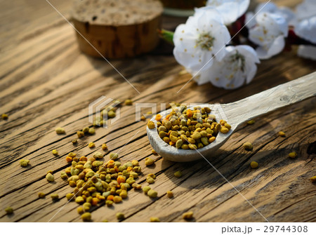 Bee pollen in a wooden spoon and flowers of spring 29744308