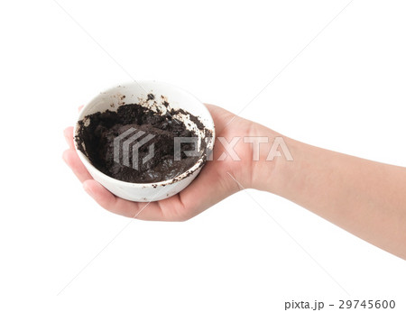 Woman's hand holding bowl of coffee grounds  29745600