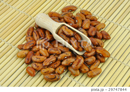 Brown pinto beans with wooden scoop on bamboo mat 29747844