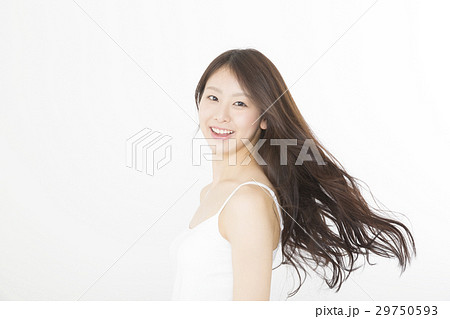 ビューティー 振り向く女性 笑顔 流れる髪 ロングヘアー キャミソール 白バックの写真素材