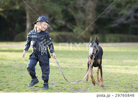 警察のコスチュームを着た女の子とドーベルマン 29760846