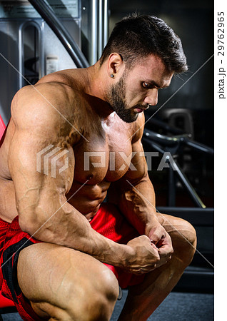 Handsome fit muscular man flexing muscles in gym Handsome fit muscular man flexing muscles in gym 29762965