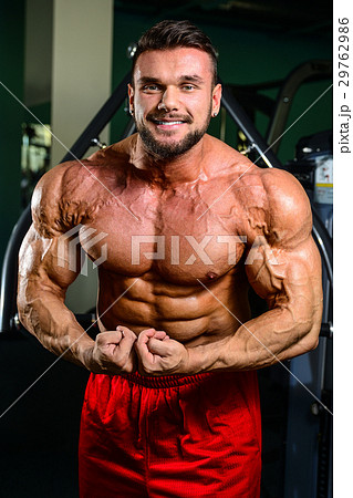 Handsome fit muscular man flexing muscles in gym Handsome fit muscular man flexing muscles in gym 29762986