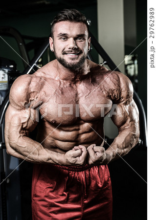 Handsome fit muscular man flexing muscles in gym Handsome fit muscular man flexing muscles in gym 29762989