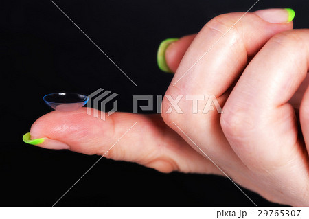 A soft contact lens on the female finger A soft contact lens on the female finger 29765307