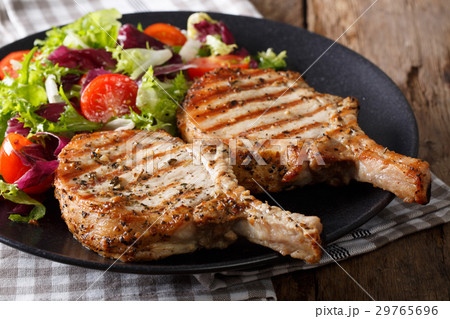 Grilled spicy pork cutlet and fresh salad close-up 29765696