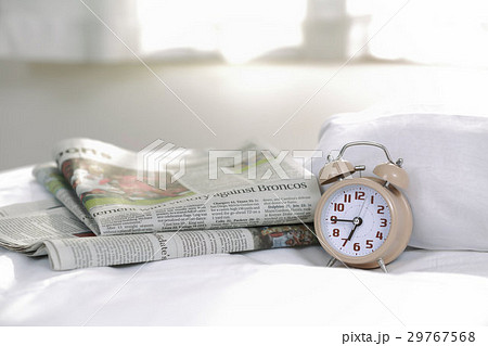 目覚まし時計(06:45)と英字新聞 29767568