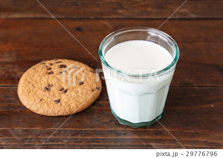 glass of milk with biscuits on wooden table 29776796
