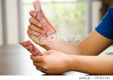 Hand holding 100 Thai baht banknote, Salary or saving money 29781191
