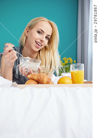 Young beautiful woman having breakfast in bed. Young beautiful woman having breakfast in bed. 29781867