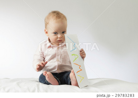 Thougtful baby holding nameplate in his hands 29783283