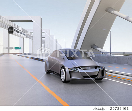 高速道路に走っているシルバー色の自動車。後ろに吊下げ式モノレールがある 29785461
