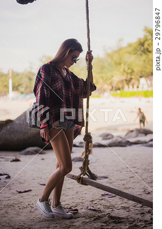 Cute girl posing on a beach. She holds a rope and 29796847