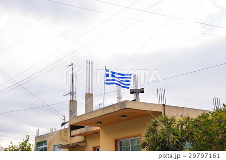 Greek flag on the roof of building, waving in the Greek flag on the roof of building, waving in the 29797161