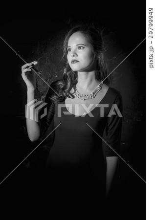 Noir film style woman in dress holding cigarette 29799949