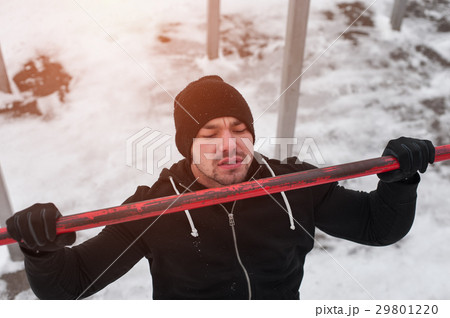 Young handsome man doing pull up exercise outdoors 29801220