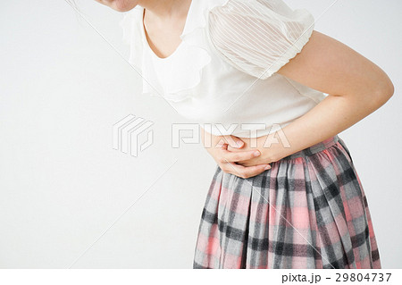 腹痛でおなかを押さえる若い女性 29804737