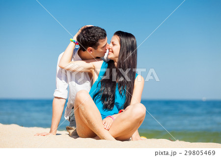 photo of cute couple sitting on the beach photo of cute couple sitting on the beach 29805469