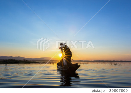 Silhouette fisherman on the boat setting net Silhouette fisherman on the boat setting net 29807809