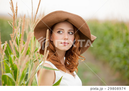 young woman standing near the growing corn 29808974